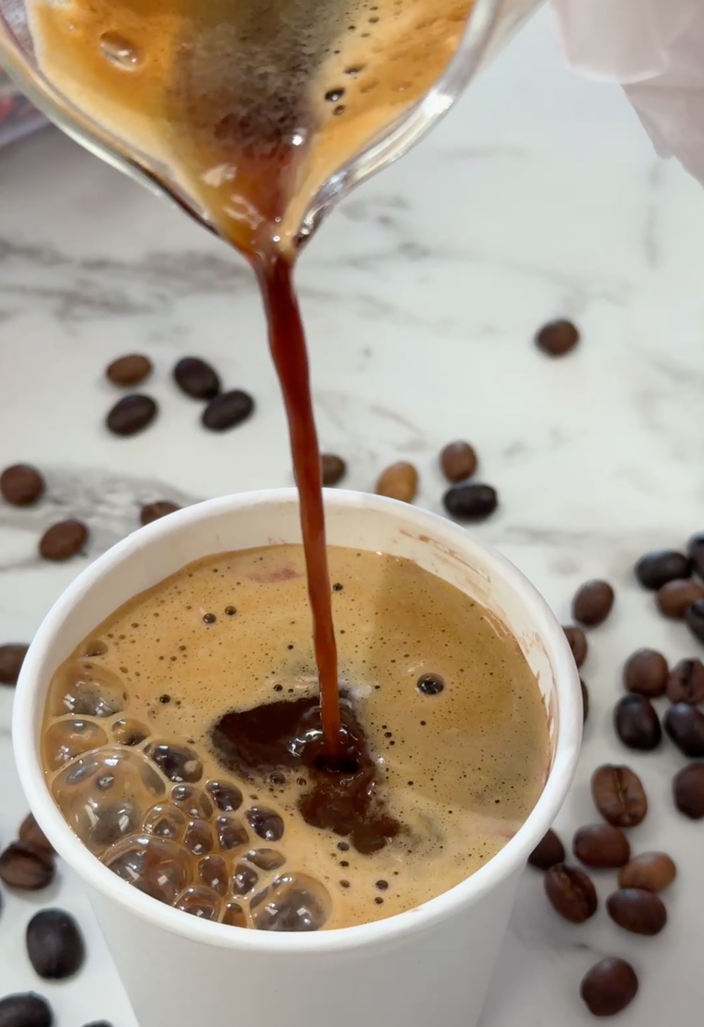 Coffee being poured over gelato to create affogato